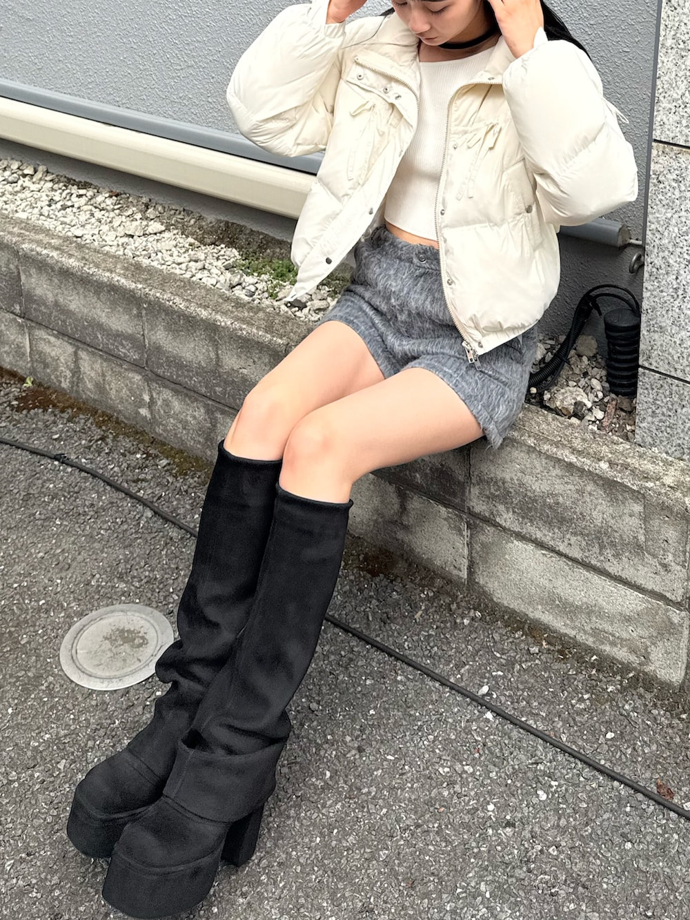 ホワイト系のダウンジャケット/コート、グレー系のその他パンツ、ブラック系のブーツを着用したレディースの冬コーディネートの2枚目の写真