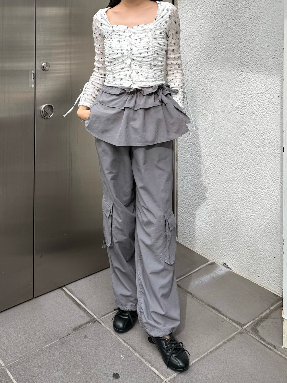 グレー系のその他パンツ、ブラック系のスニーカー、ホワイト系のTシャツ/カットソーを着用したレディースの冬コーディネートの2枚目の写真