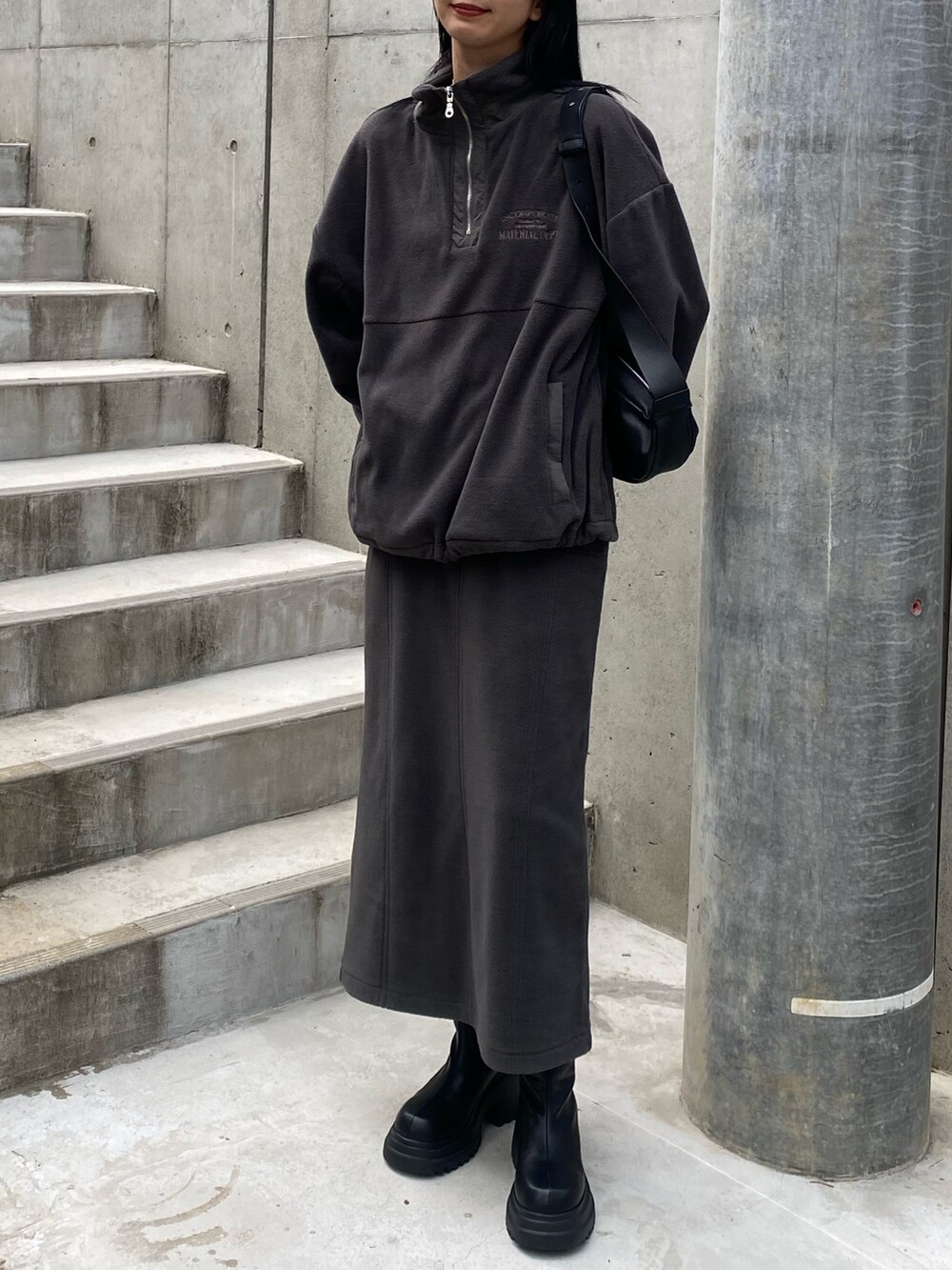 グレー系のスカート、ブラック系のショルダーバッグ、グレー系のTシャツ/カットソーを着用したレディースの秋コーディネートの3枚目の写真