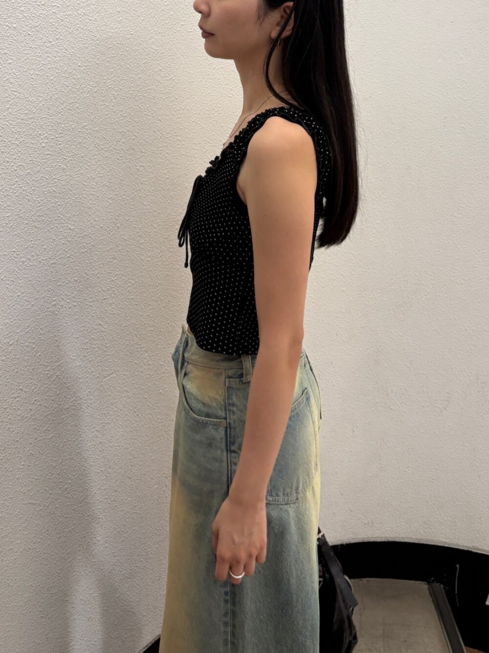 ブルー系のデニムパンツ、ブラック系のハンドバッグ、ブラック系のサンダルを着用したレディースの夏コーディネートの7枚目の写真