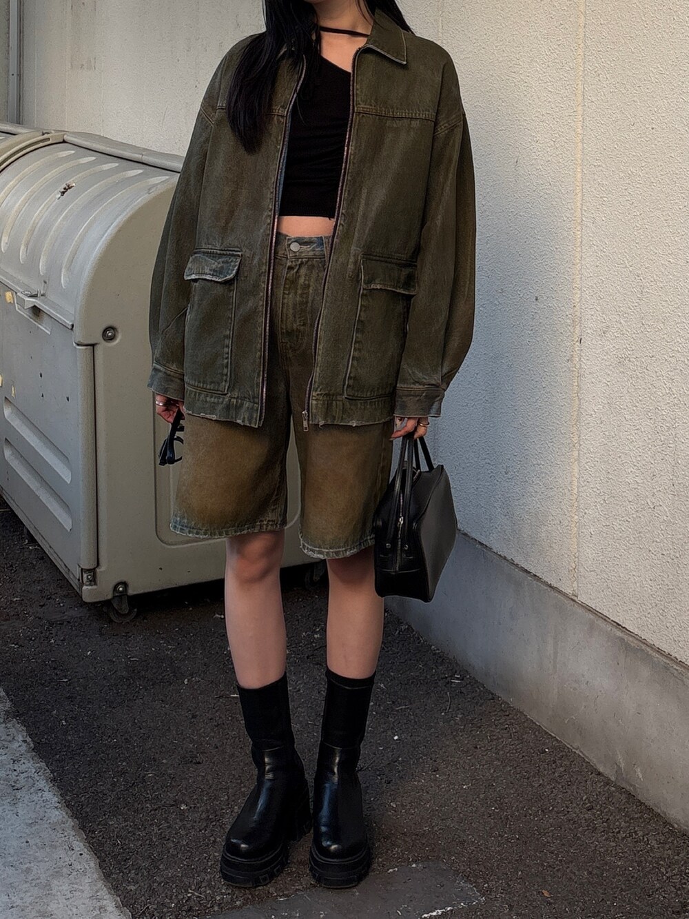 ブラウン系のデニムパンツ、ブラウン系のブルゾン、ブラック系のニット/セーターを着用したレディースの冬コーディネートの4枚目の写真