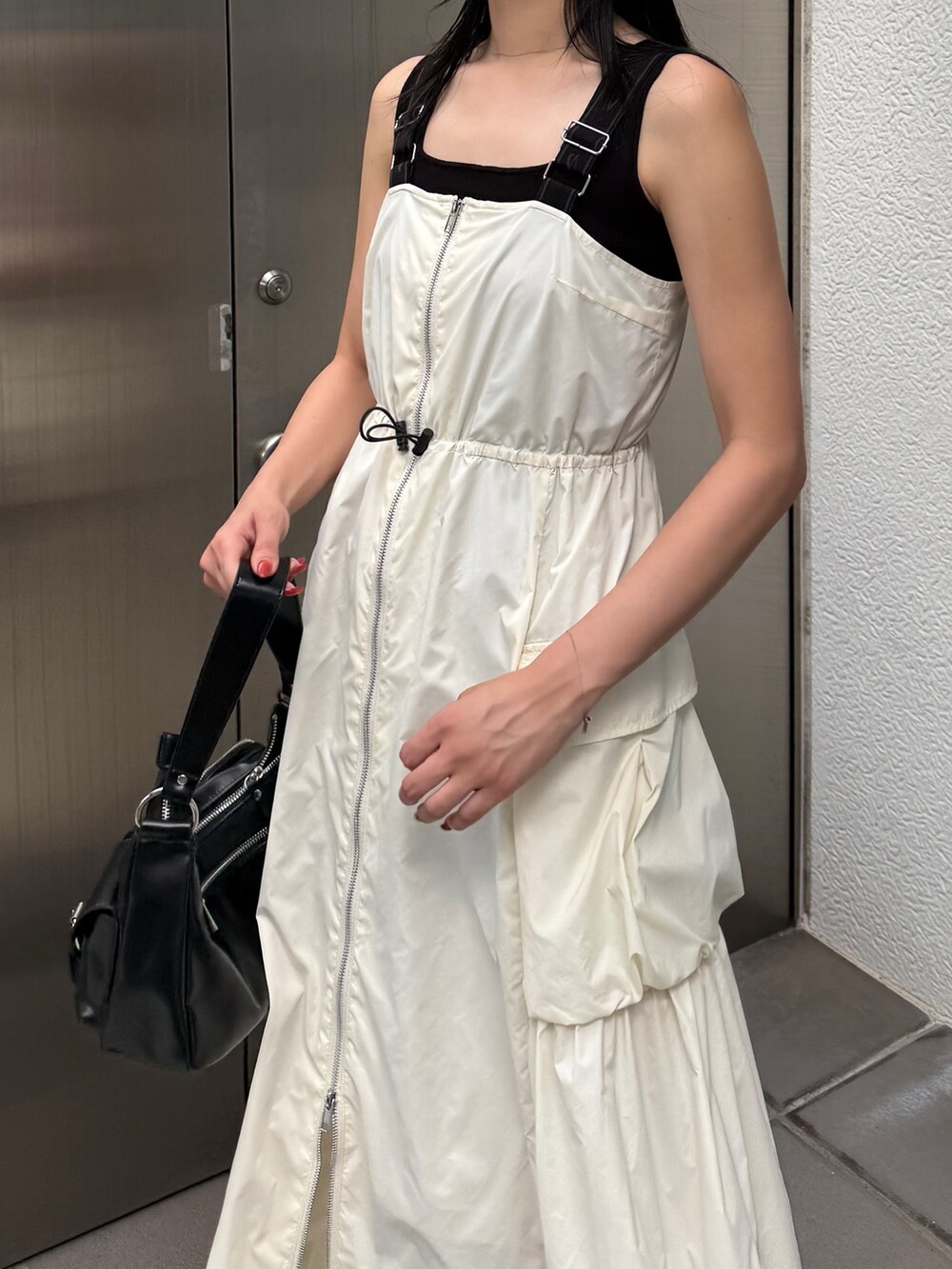 ホワイト系のワンピース、ブラック系のブーツを着用したレディースの夏コーディネートの3枚目の写真