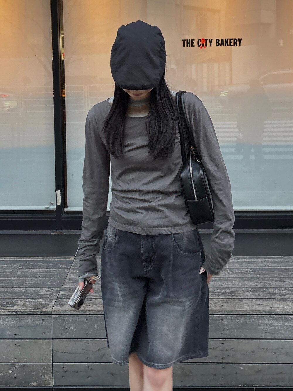 グレー系のTシャツ/カットソー、ブラック系のデニムパンツ、ブラック系のハンドバッグを着用したレディースの冬コーディネートの3枚目の写真