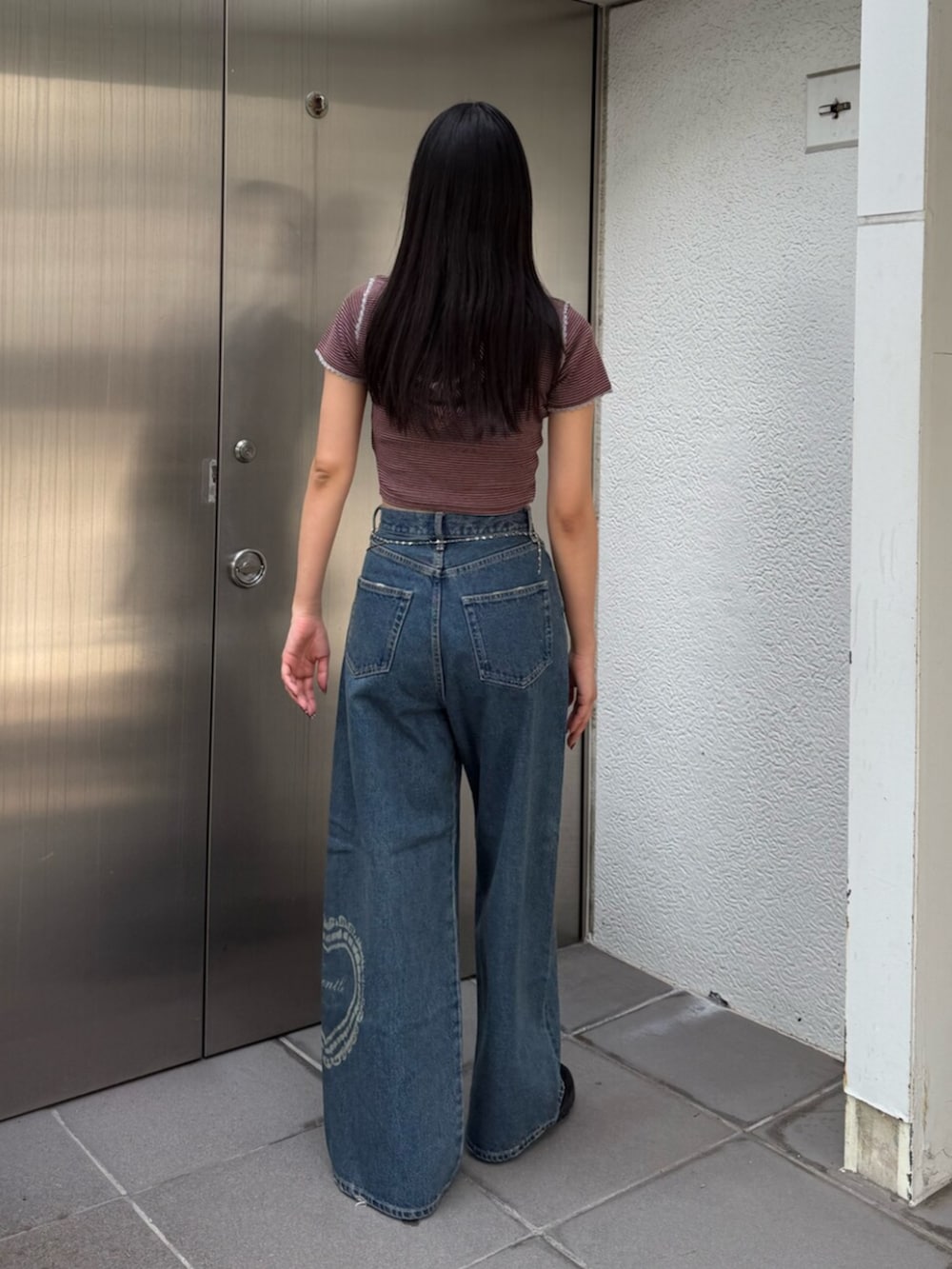 ブルー系のデニムパンツ、レッド系のTシャツ/カットソー、ブラウン系のスニーカーを着用したレディースの夏コーディネートの3枚目の写真