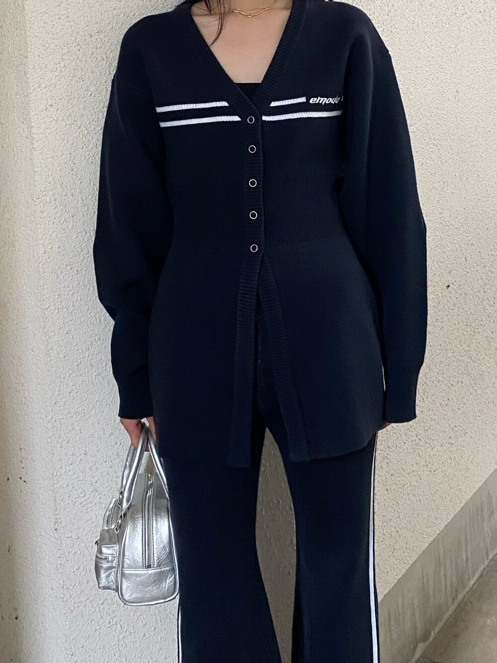 シルバー系のハンドバッグ、ブルー系のその他パンツ、ブラック系のブーツを着用したレディースの秋コーディネートの3枚目の写真