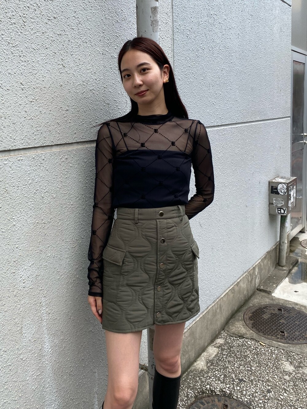 ブラック系のTシャツ/カットソー、グリーン系のスカート、ブラック系のブーツを着用したレディースの秋コーディネートの3枚目の写真