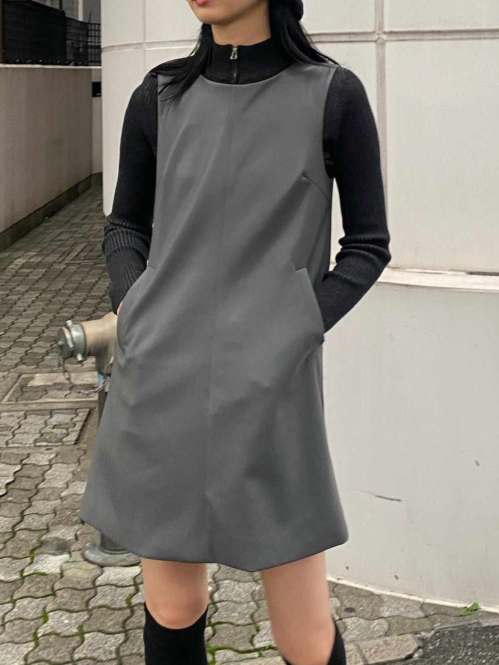 グレー系のワンピース、ブラック系のニット/セーター、ブラック系のサンダルを着用したレディースの秋コーディネートの2枚目の写真