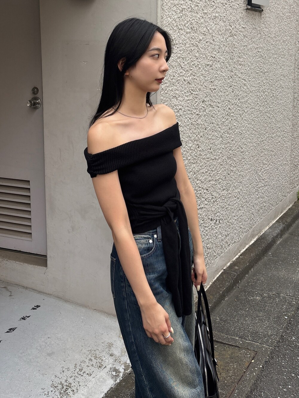 ブルー系のデニムパンツ、ブラック系のパンプス、ブラック系のニット/セーターを着用したレディースの春コーディネートの3枚目の写真