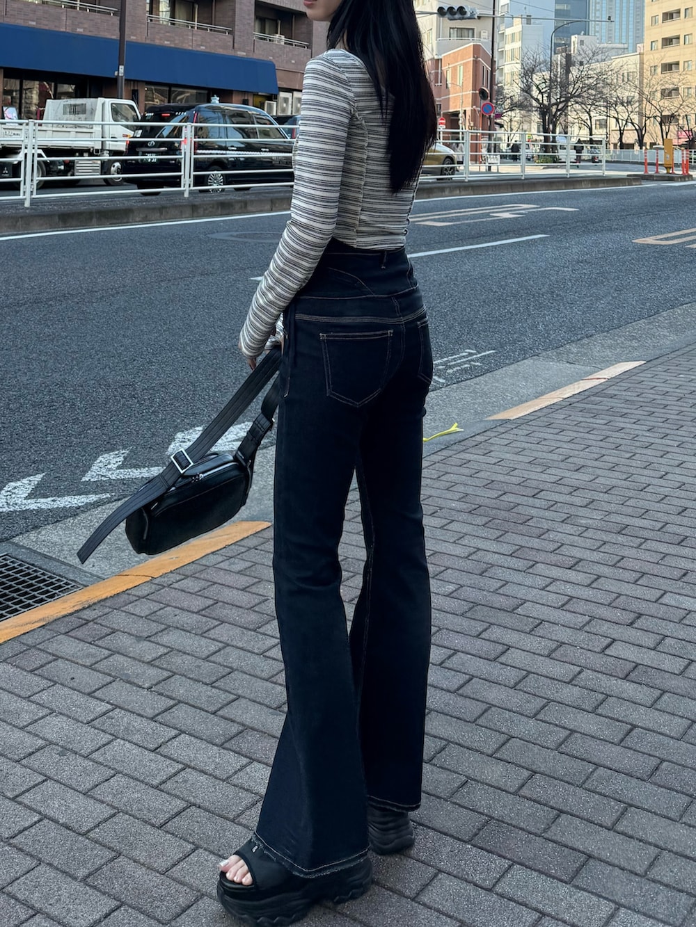 ブルー系のデニムパンツ、その他のTシャツ/カットソー、ブラック系のショルダーバッグを着用したレディースの春コーディネートの3枚目の写真