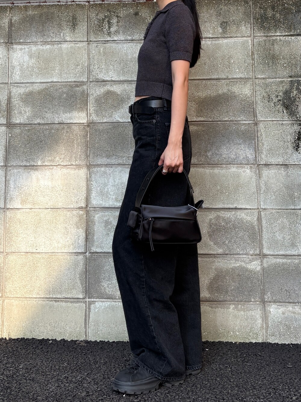 ブラック系のニット/セーター、ブラック系のサンダル、ブラック系のハンドバッグを着用したレディースの夏コーディネートの2枚目の写真