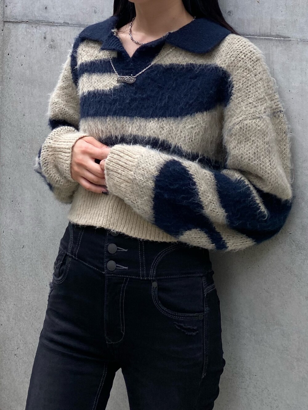 ブラック系のデニムパンツ、ブルー系のニット/セーター、ブラック系のローファーを着用したレディースの秋コーディネートの2枚目の写真