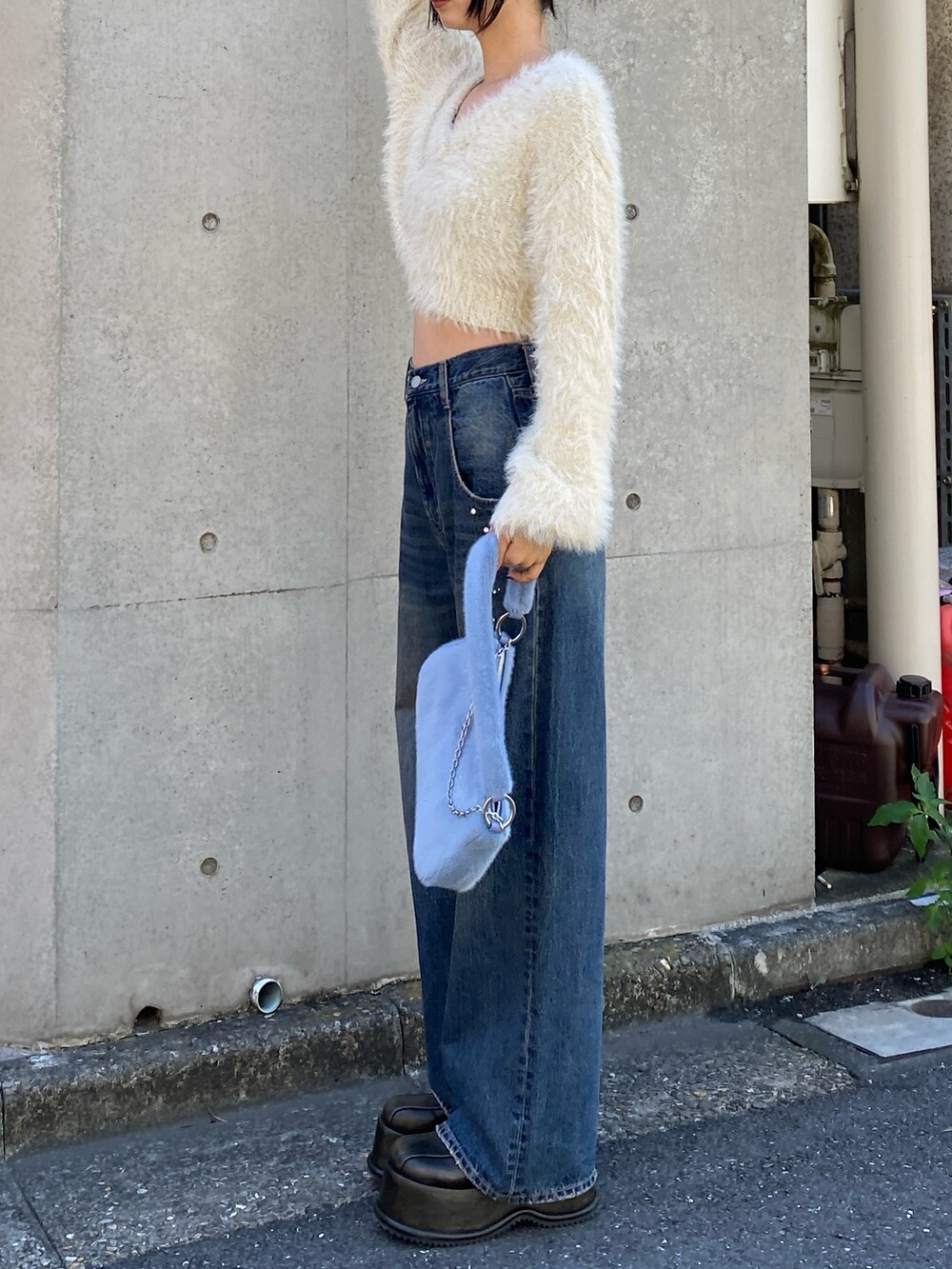 ブルー系のデニムパンツ、ホワイト系のニット/セーターを着用したレディースの秋コーディネートの2枚目の写真