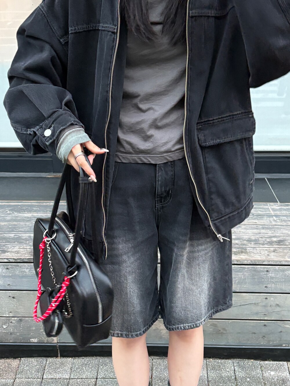 グレー系のTシャツ/カットソー、ブラック系のデニムパンツ、ブラック系のハンドバッグを着用したレディースの冬コーディネートの4枚目の写真