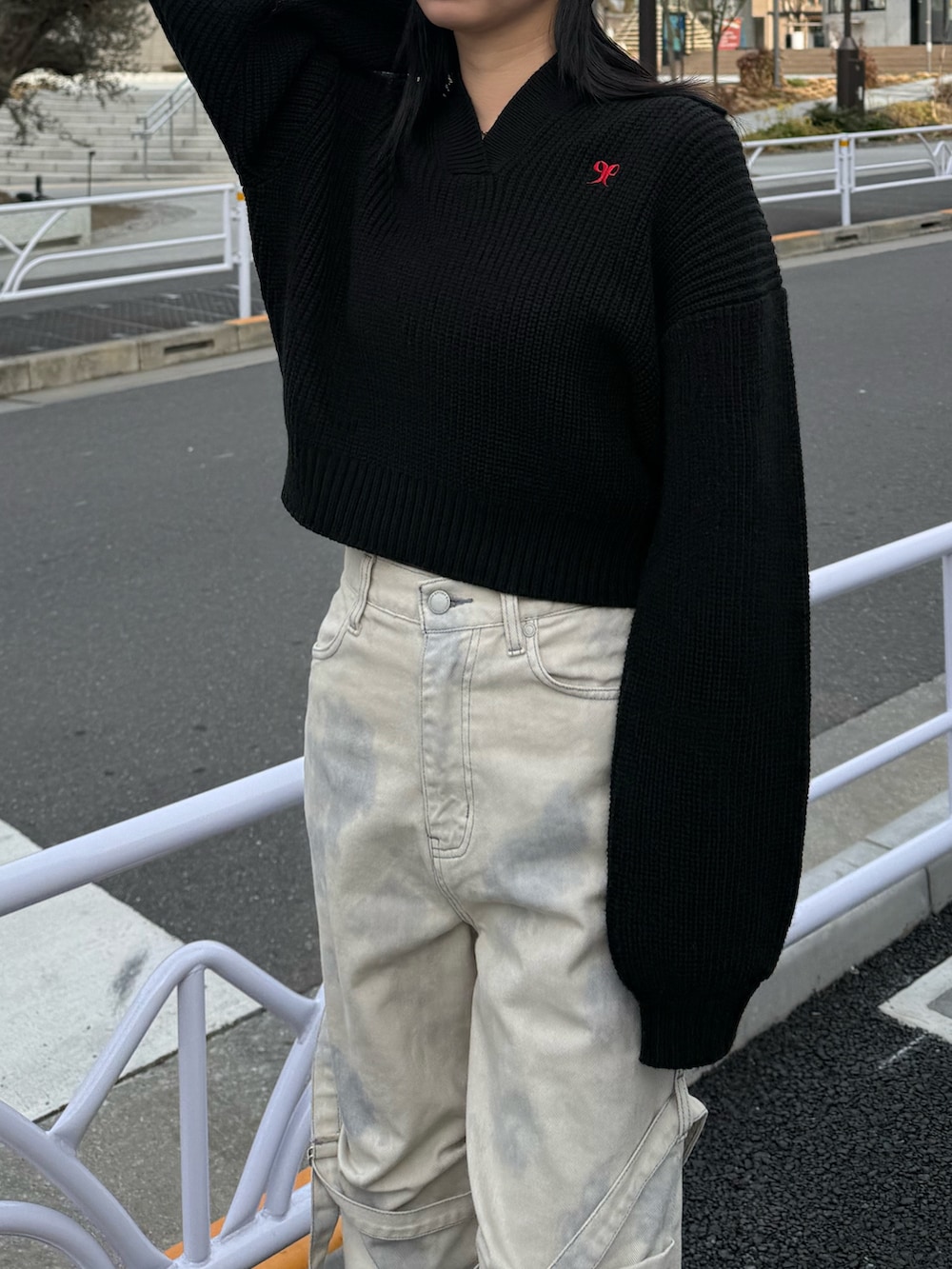 ホワイト系のデニムパンツ、ブラック系のニット/セーター、ブラック系のスニーカーを着用したレディースの冬コーディネートの4枚目の写真