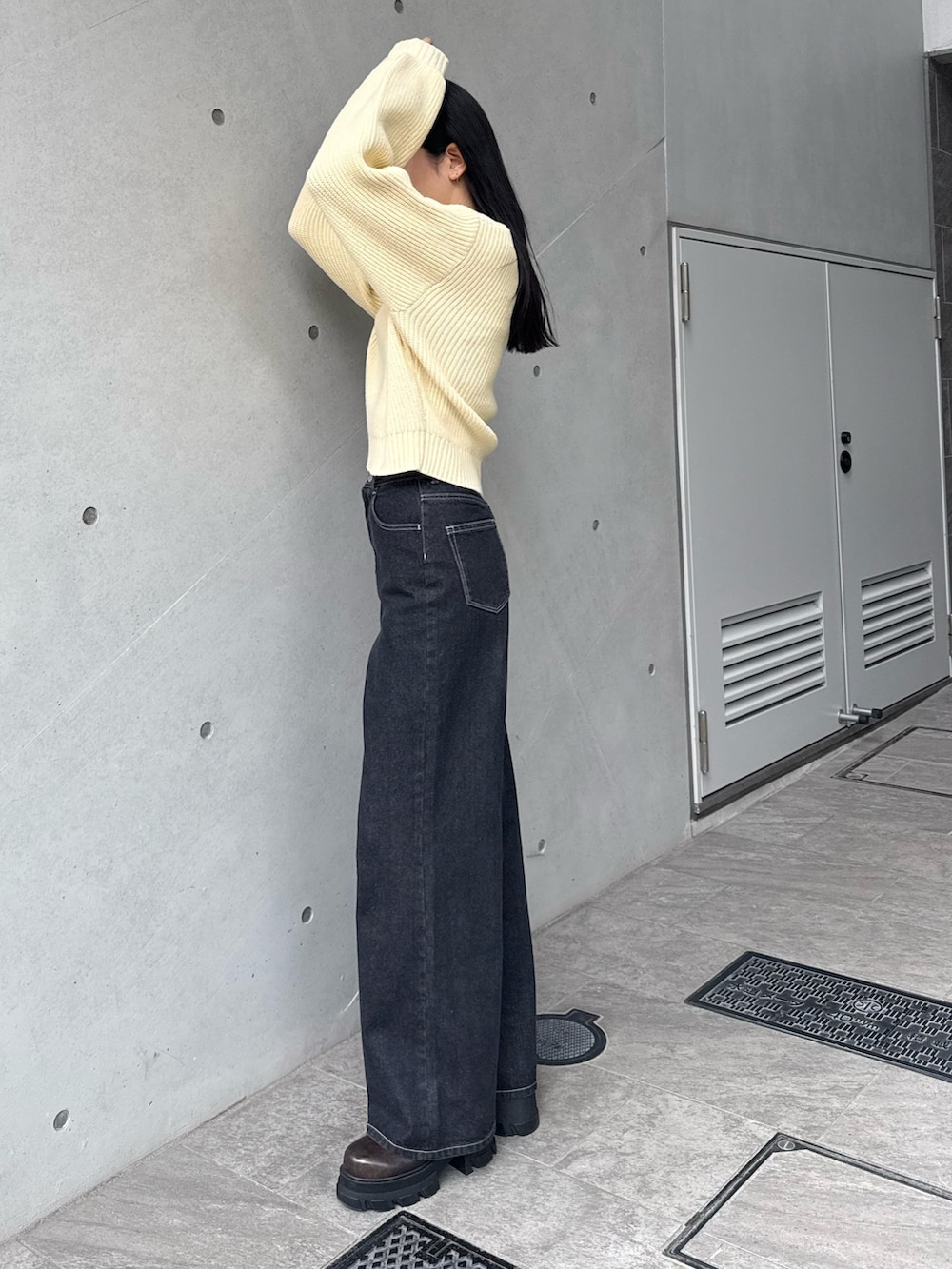 ブルー系のデニムパンツ、イエロー系のニット/セーターを着用したレディースの冬コーディネートの2枚目の写真