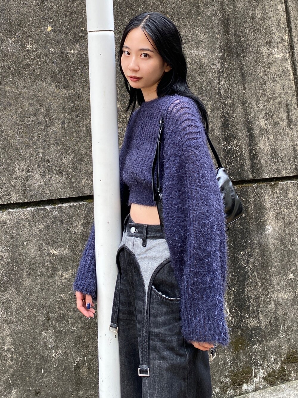 ブルー系のニット/セーター、ブラック系のデニムパンツを着用したレディースの秋コーディネートの2枚目の写真