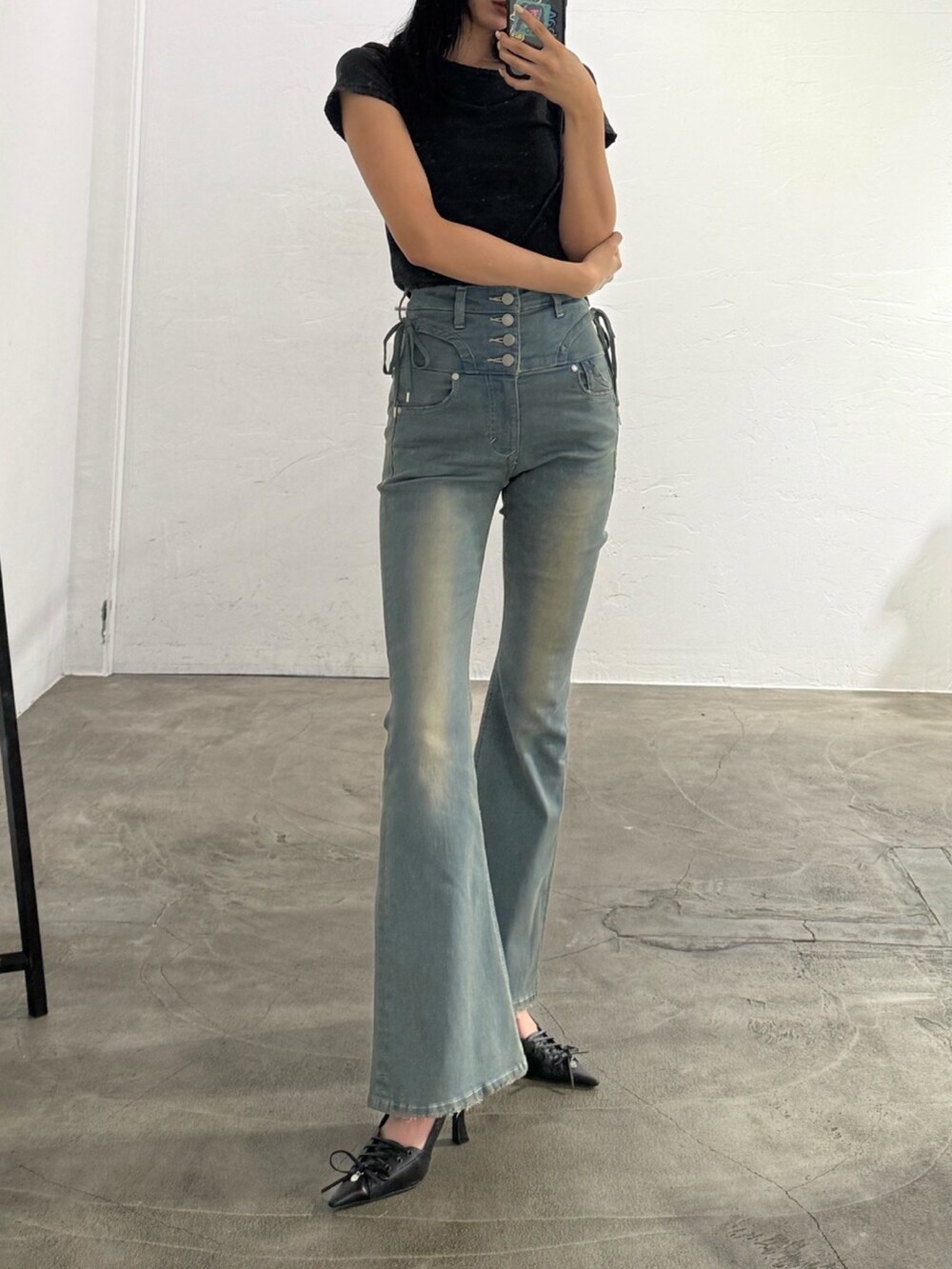 ブルー系のデニムパンツ、ブラック系のパンプスを着用したレディースの春コーディネートの2枚目の写真