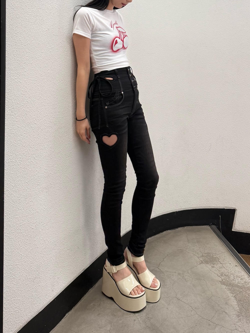 ブラック系のデニムパンツ、ホワイト系のTシャツ/カットソー、ホワイト系のサンダルを着用したレディースの春コーディネートの3枚目の写真