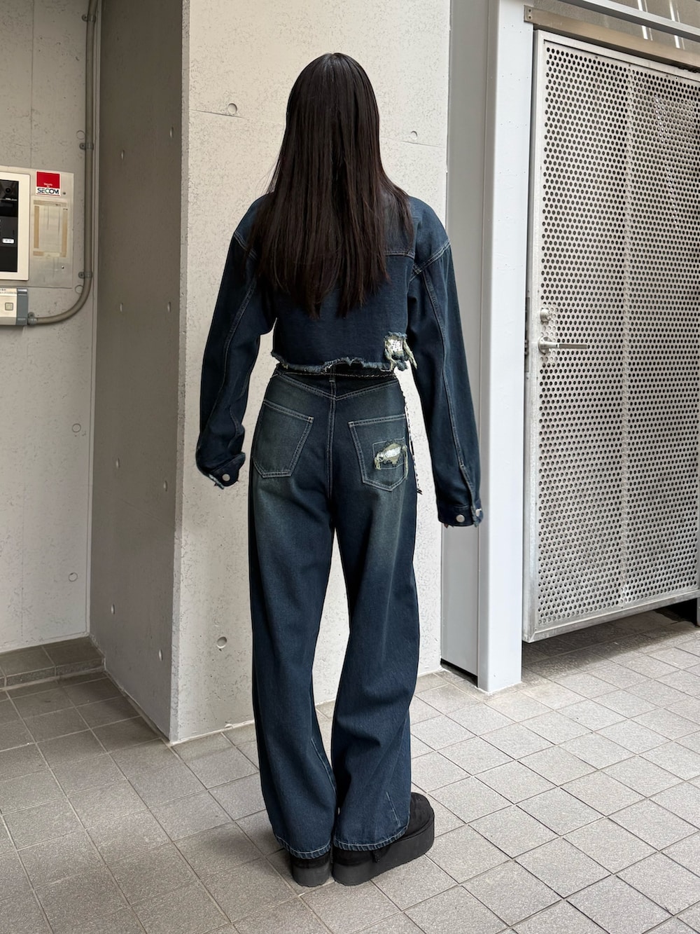 ブルー系のデニムパンツ、ブルー系のブルゾン、ブラック系のスリッポンを着用したレディースの秋コーディネートの3枚目の写真