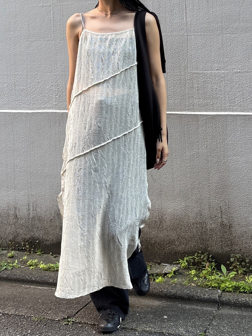 ホワイト系のワンピース、ブラック系のデニムパンツ、ブラック系のショルダーバッグを着用したレディースの夏コーディネートの2枚目の写真