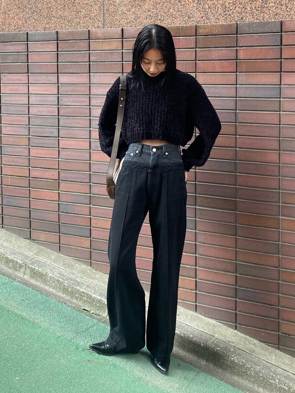 ブラック系のデニムパンツ、ブラック系のニット/セーターを着用したレディースの秋コーディネートの3枚目の写真