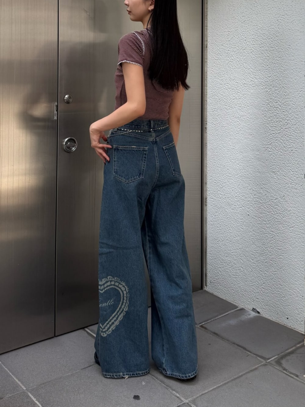 ブルー系のデニムパンツ、レッド系のTシャツ/カットソー、ブラウン系のスニーカーを着用したレディースの夏コーディネートの2枚目の写真