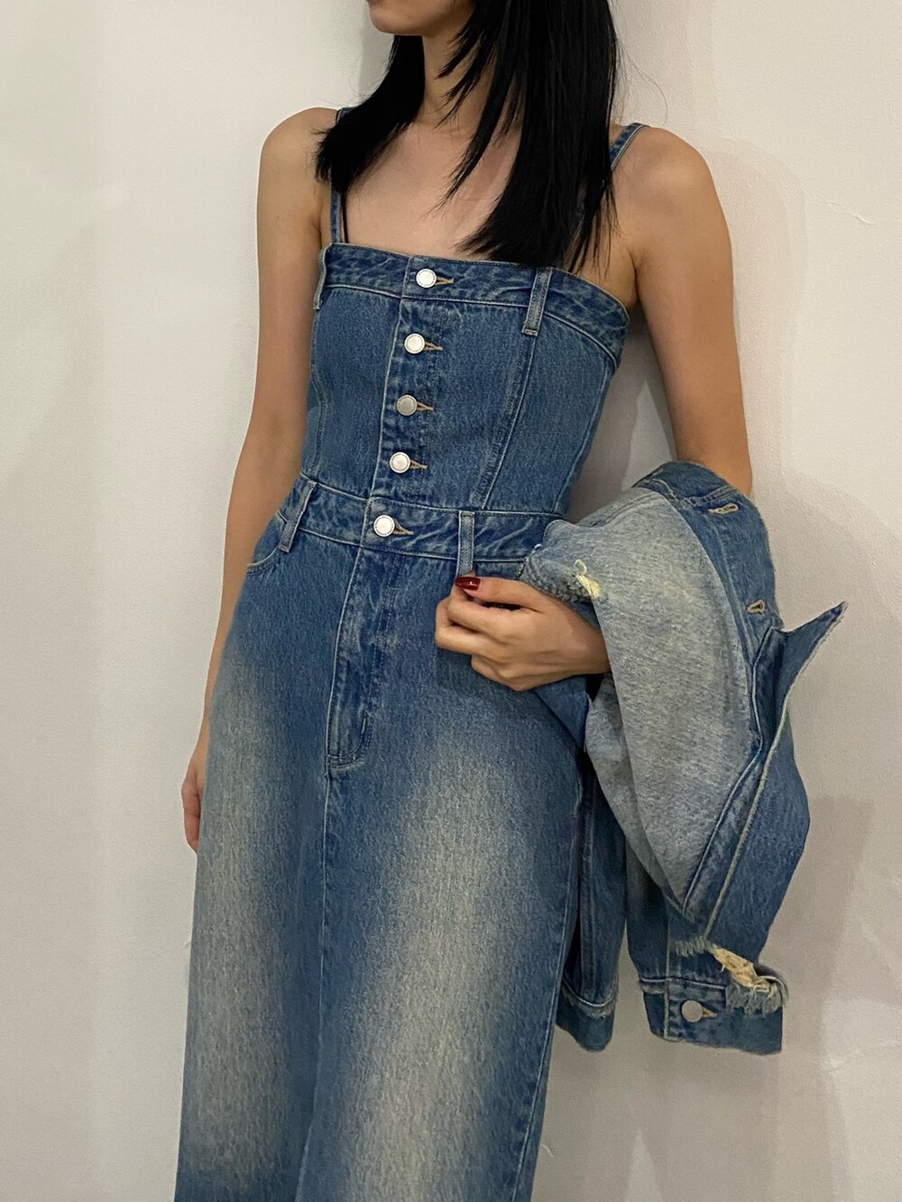 ブルー系のワンピース、ブルー系のデニムジャケット、ブラック系のブーツを着用したレディースの春コーディネートの2枚目の写真