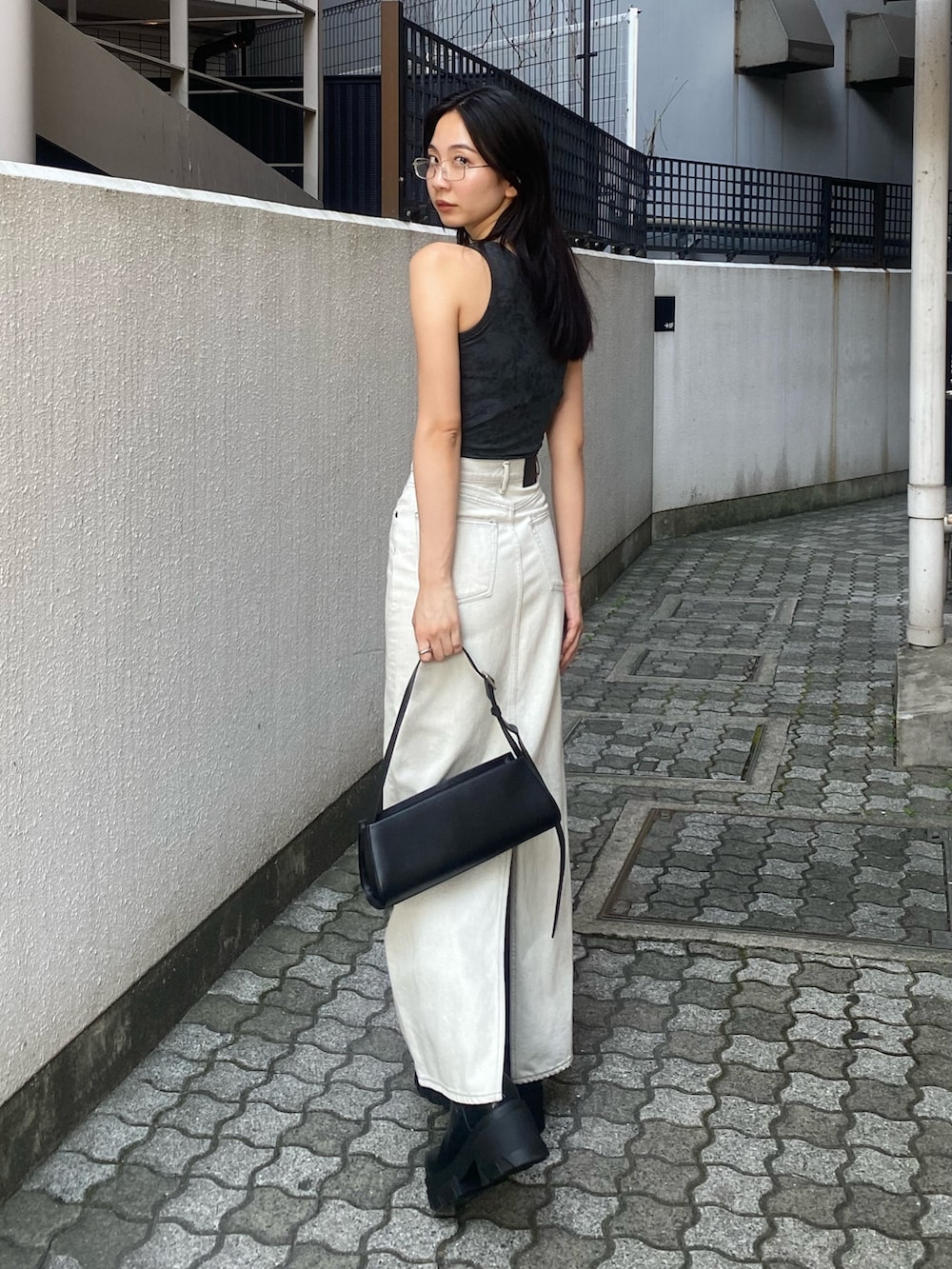 グレー系のタンクトップ、ホワイト系のスカートを着用したレディースの夏コーディネートの2枚目の写真