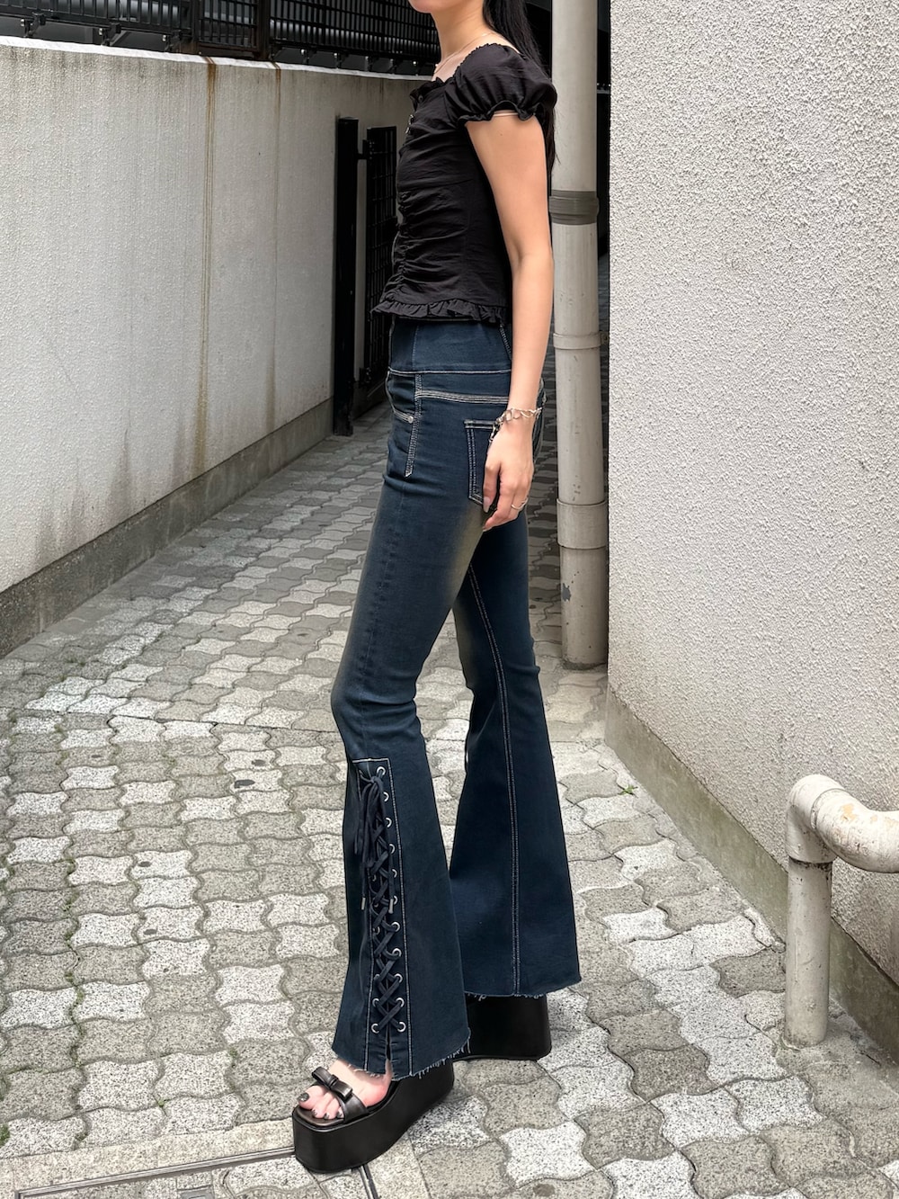 ブルー系のデニムパンツ、ブラック系のサンダル、ブラック系のシャツ/ブラウスを着用したレディースの夏コーディネートの2枚目の写真