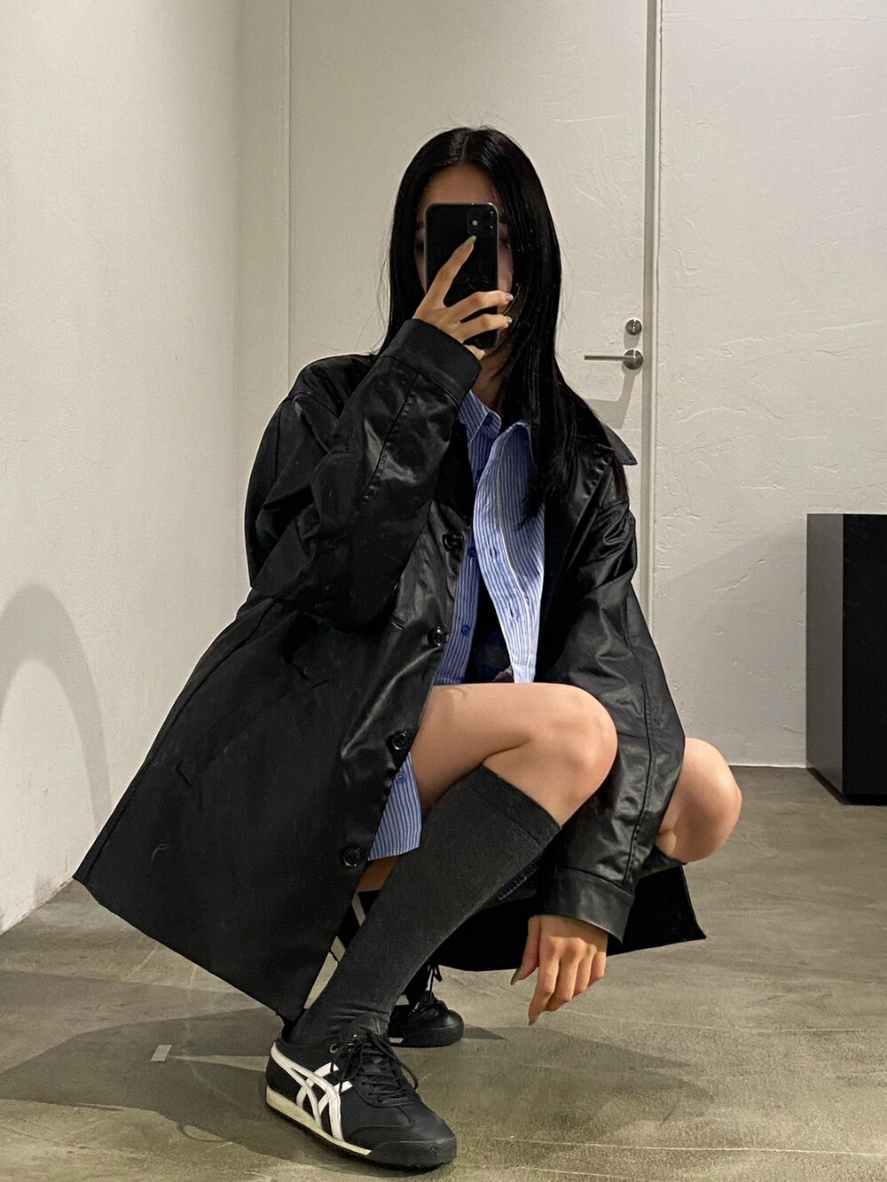 ブラック系のナイロンジャケット、ブルー系のシャツ/ブラウスを着用したレディースの春コーディネートの3枚目の写真