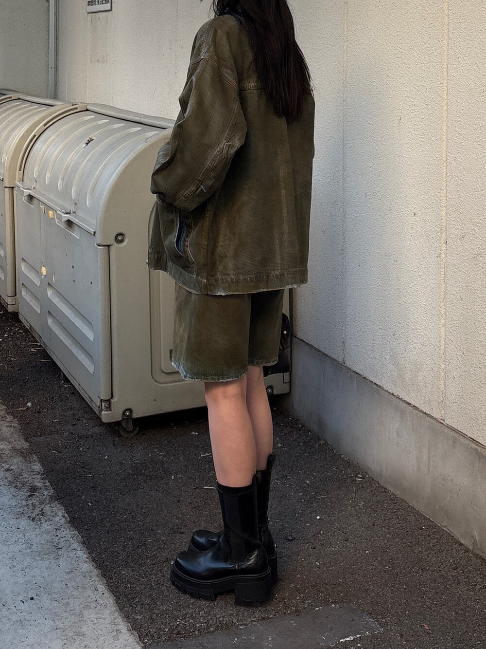 ブラウン系のデニムパンツ、ブラウン系のブルゾン、ブラック系のニット/セーターを着用したレディースの冬コーディネートの2枚目の写真