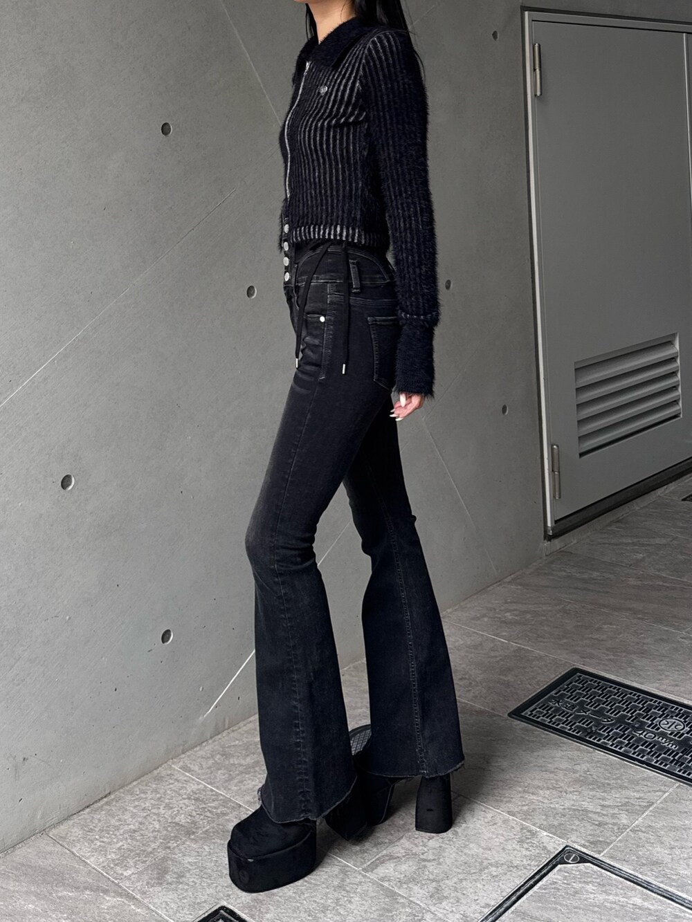 ブラック系のブーツ、ブラック系のデニムパンツ、ブラック系のニット/セーターを着用したレディースの秋コーディネートの2枚目の写真