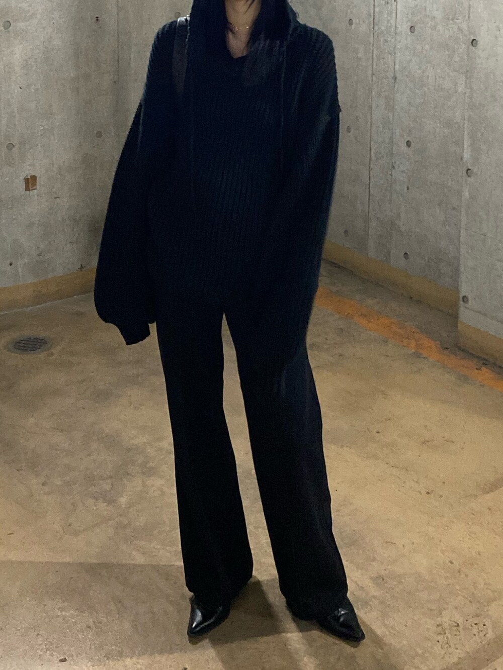 ブラック系のニット/セーター、ブラック系のデニムパンツを着用したレディースの秋コーディネートの2枚目の写真