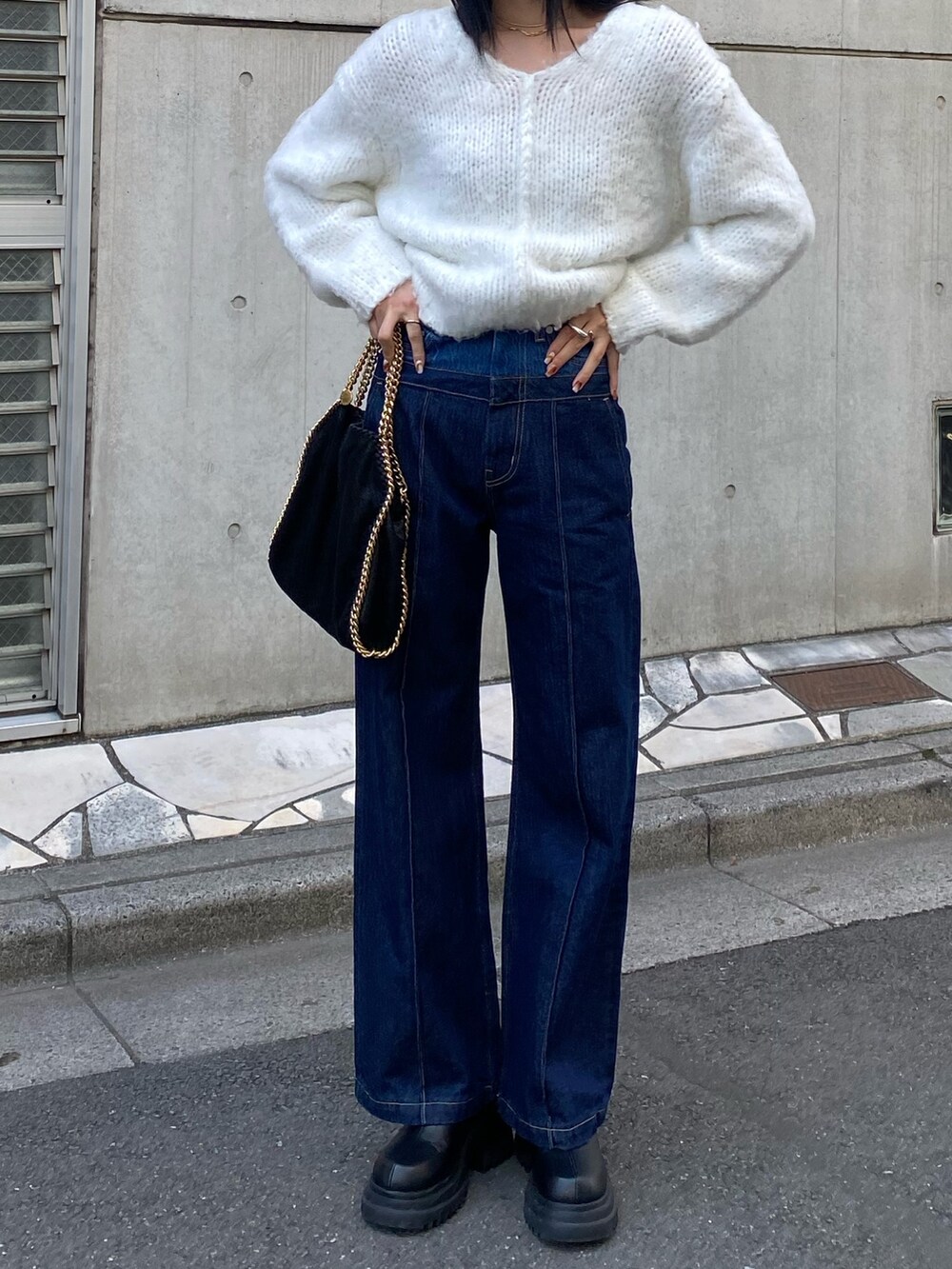 ホワイト系のニット/セーター、ブルー系のデニムパンツ、ブラック系のブーツを着用したレディースの冬コーディネートの3枚目の写真