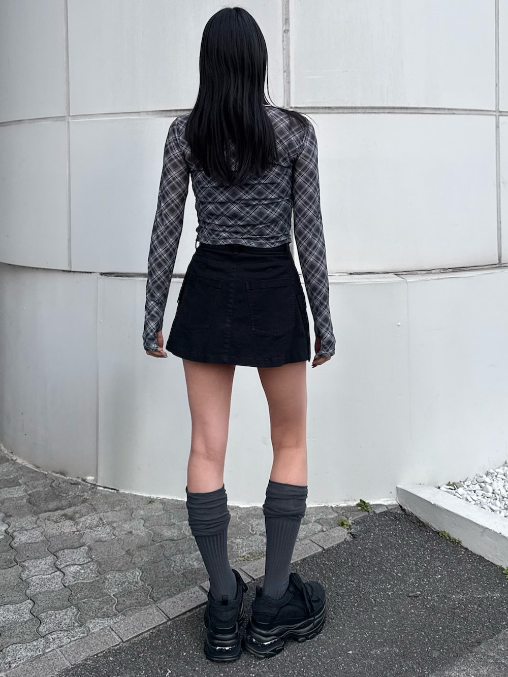 ブラック系のTシャツ/カットソー、ブラック系のスニーカー、ブラック系のスカートを着用したレディースの冬コーディネートの2枚目の写真