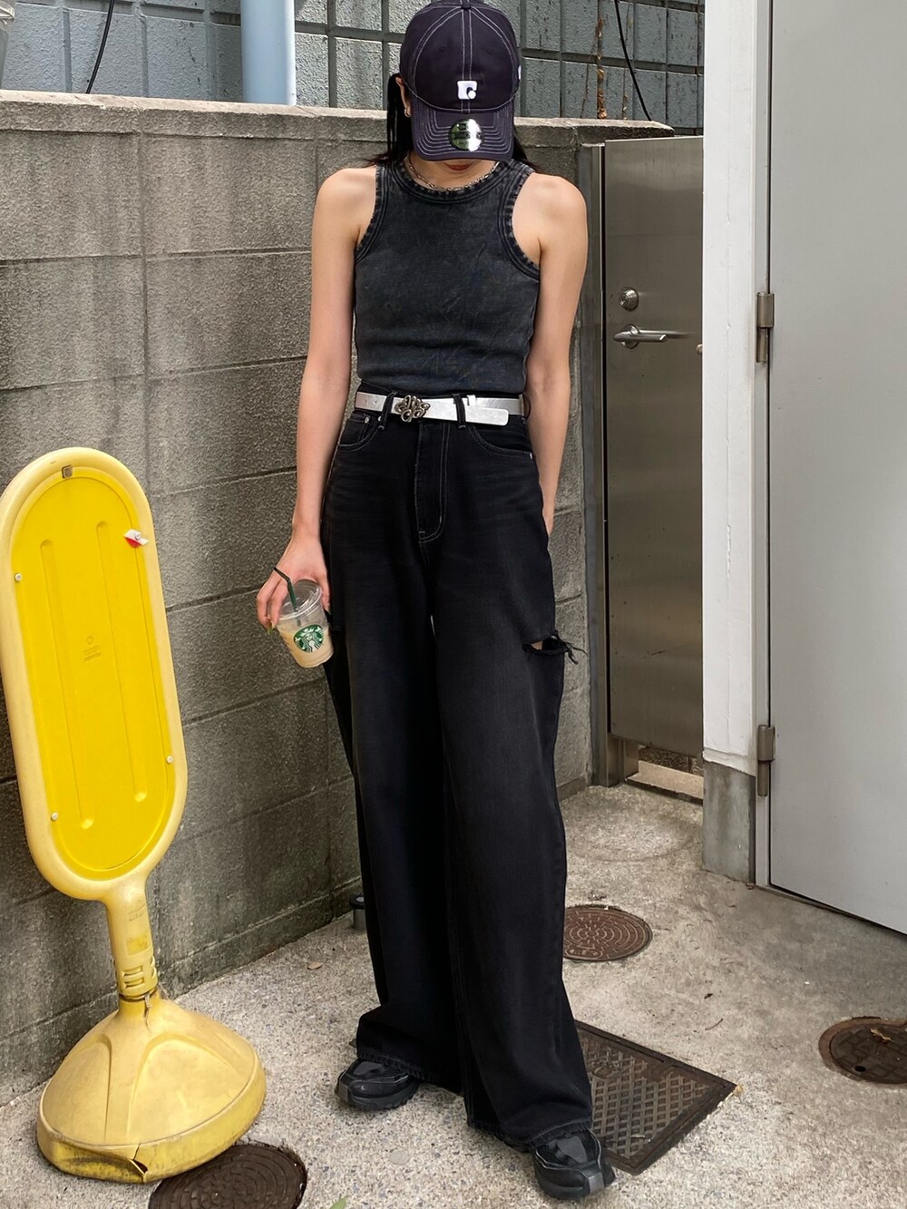 ブラック系のデニムパンツ、ブラック系のタンクトップ、ブルー系のキャップを着用したレディースの夏コーディネートの2枚目の写真