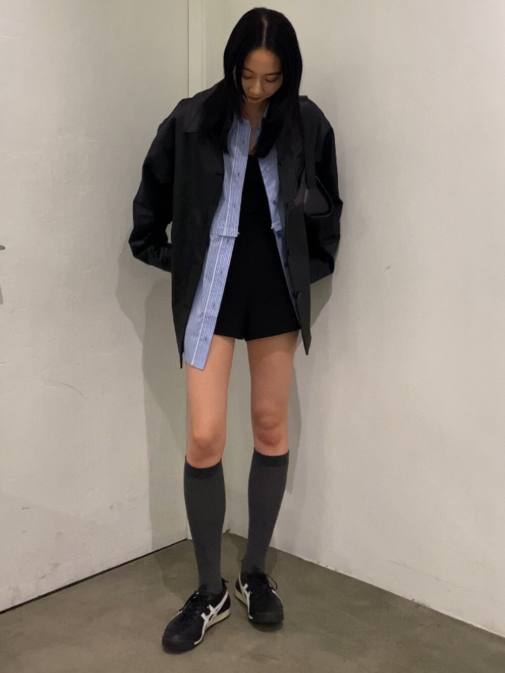 ブラック系のナイロンジャケット、ブルー系のシャツ/ブラウスを着用したレディースの春コーディネートの2枚目の写真