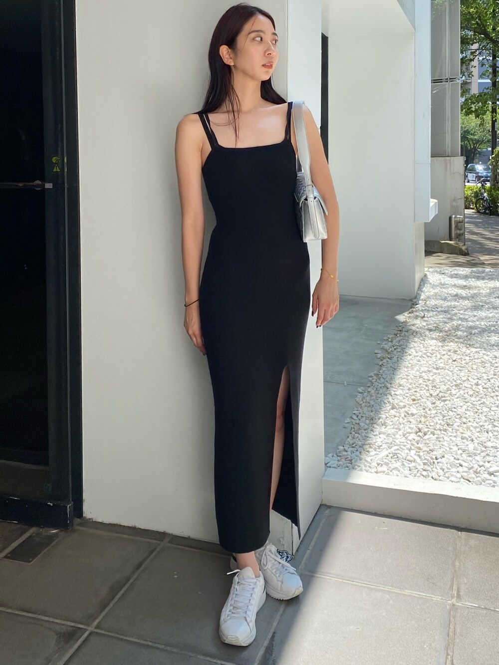 シルバー系のハンドバッグ、ブラック系のワンピースを着用したレディースの夏コーディネートの4枚目の写真