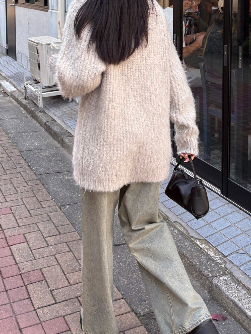 ブルー系のデニムパンツ、ホワイト系のニット/セーターを着用したレディースの秋コーディネートの2枚目の写真