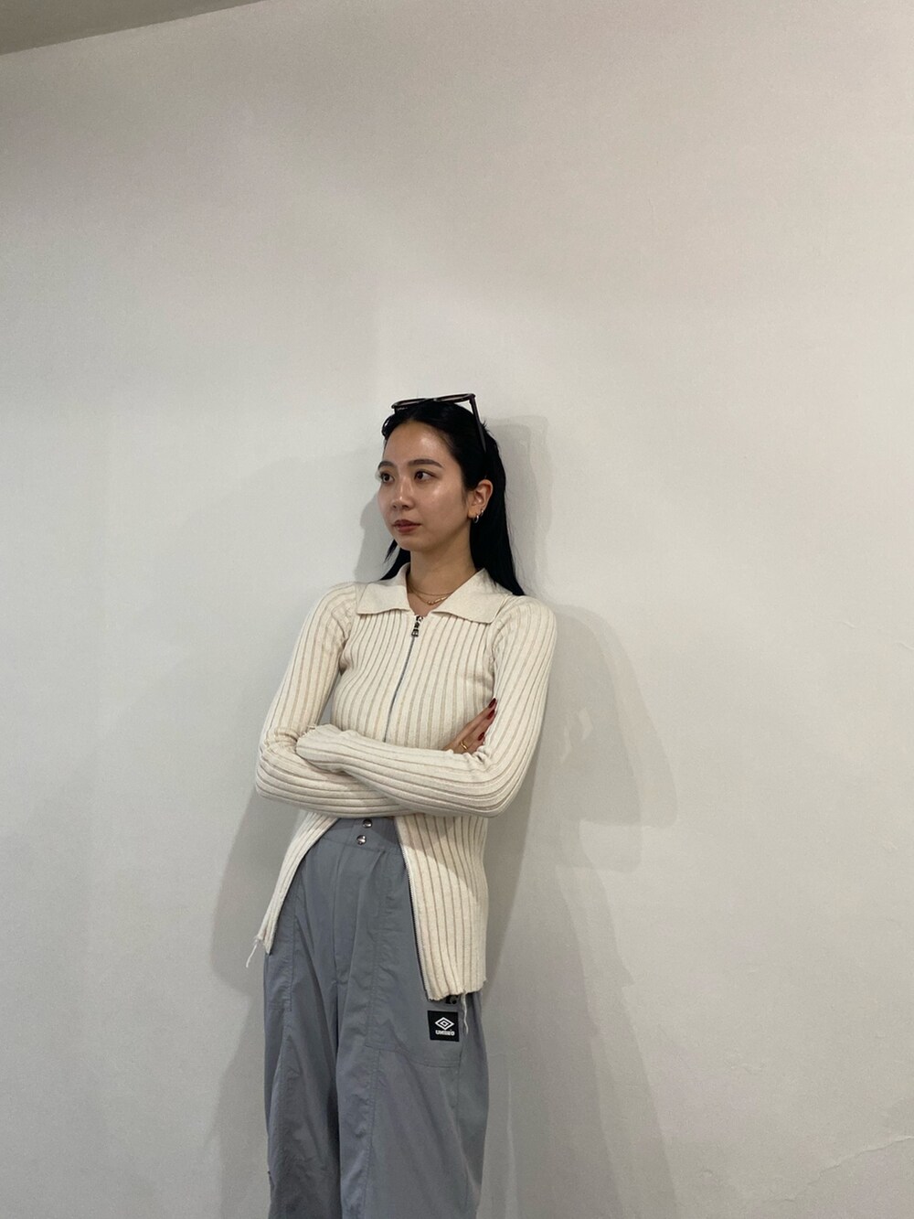 グレー系のその他パンツ、ホワイト系のニット/セーターを着用したレディースの春コーディネートの2枚目の写真