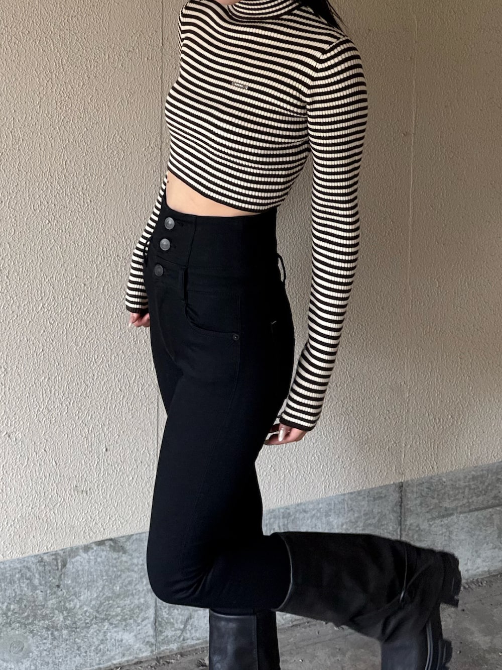 ブラック系のデニムパンツ、ブラウン系のニット/セーター、ブラック系のブーツを着用したレディースの冬コーディネートの3枚目の写真