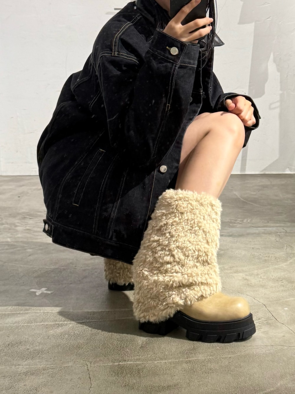 ブルー系のブルゾン、ブルー系のスカート、ホワイト系のブーツを着用したレディースの冬コーディネートの3枚目の写真