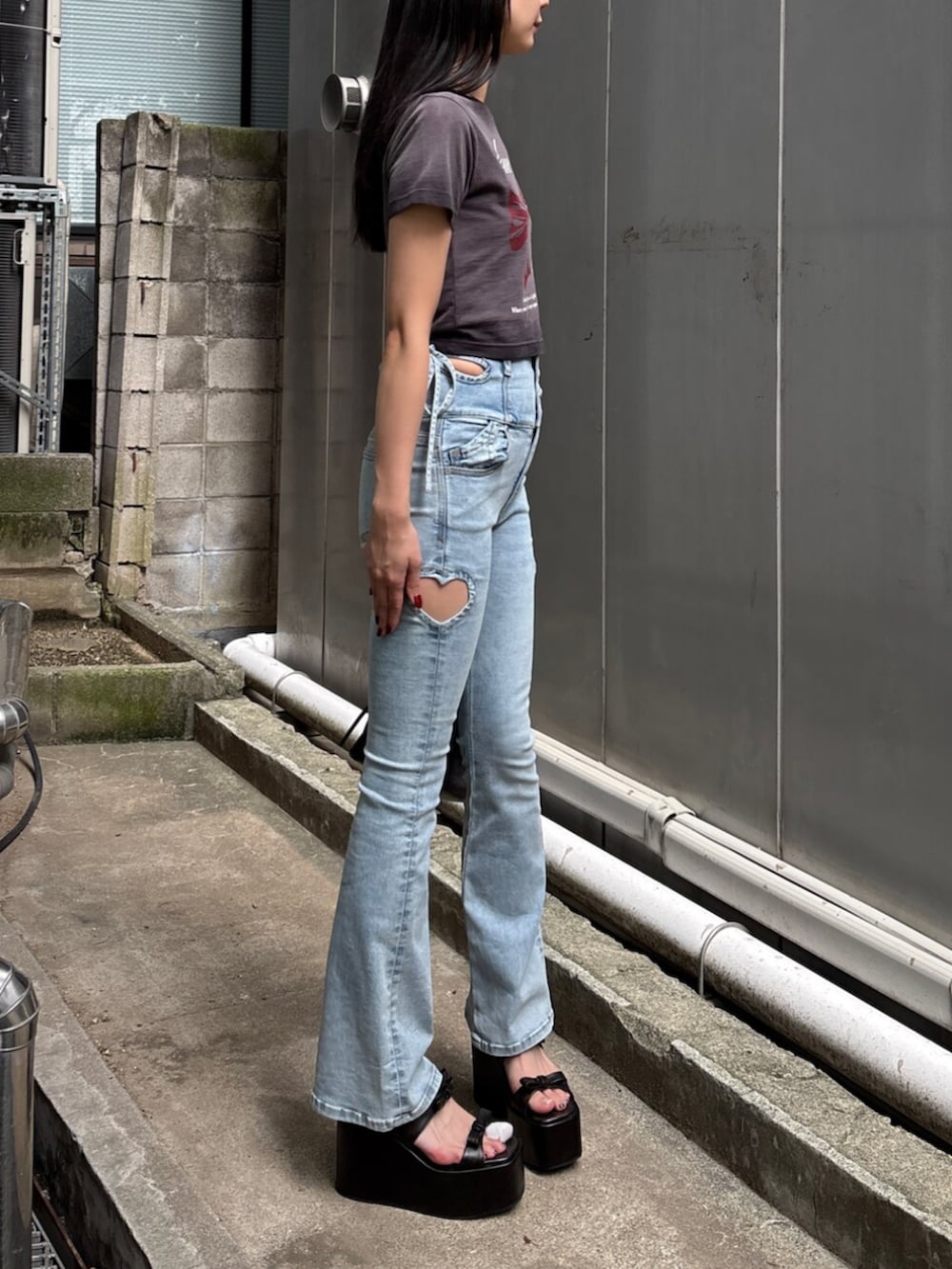 ブラック系のサンダル、ブラック系のTシャツ/カットソー、ブルー系のデニムパンツを着用したレディースの夏コーディネートの4枚目の写真