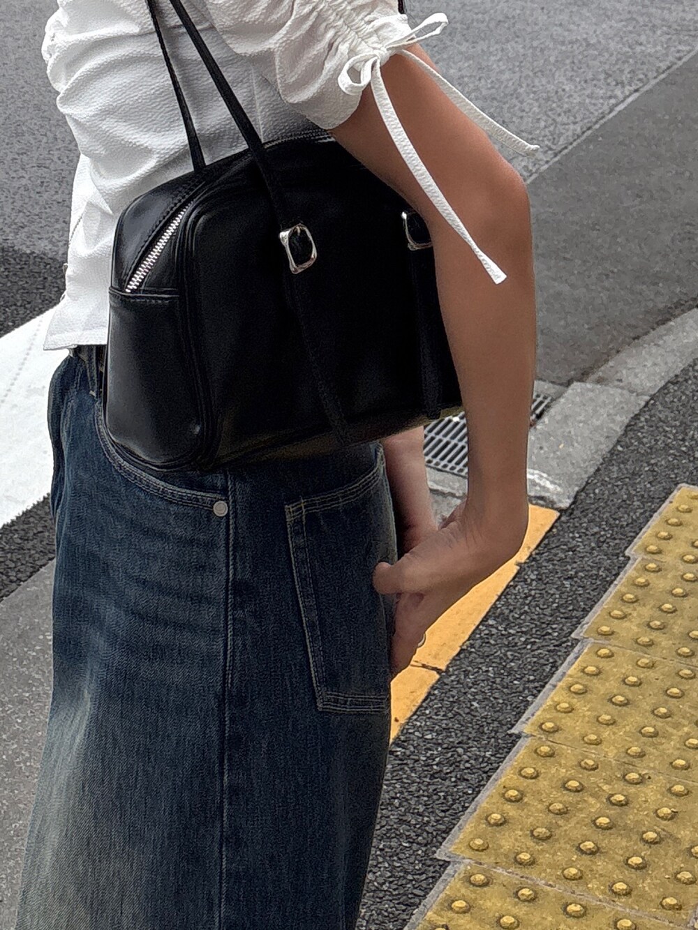 ブルー系のデニムパンツ、ブラック系のサンダル、ホワイト系のシャツ/ブラウスを着用したレディースの春コーディネートの4枚目の写真