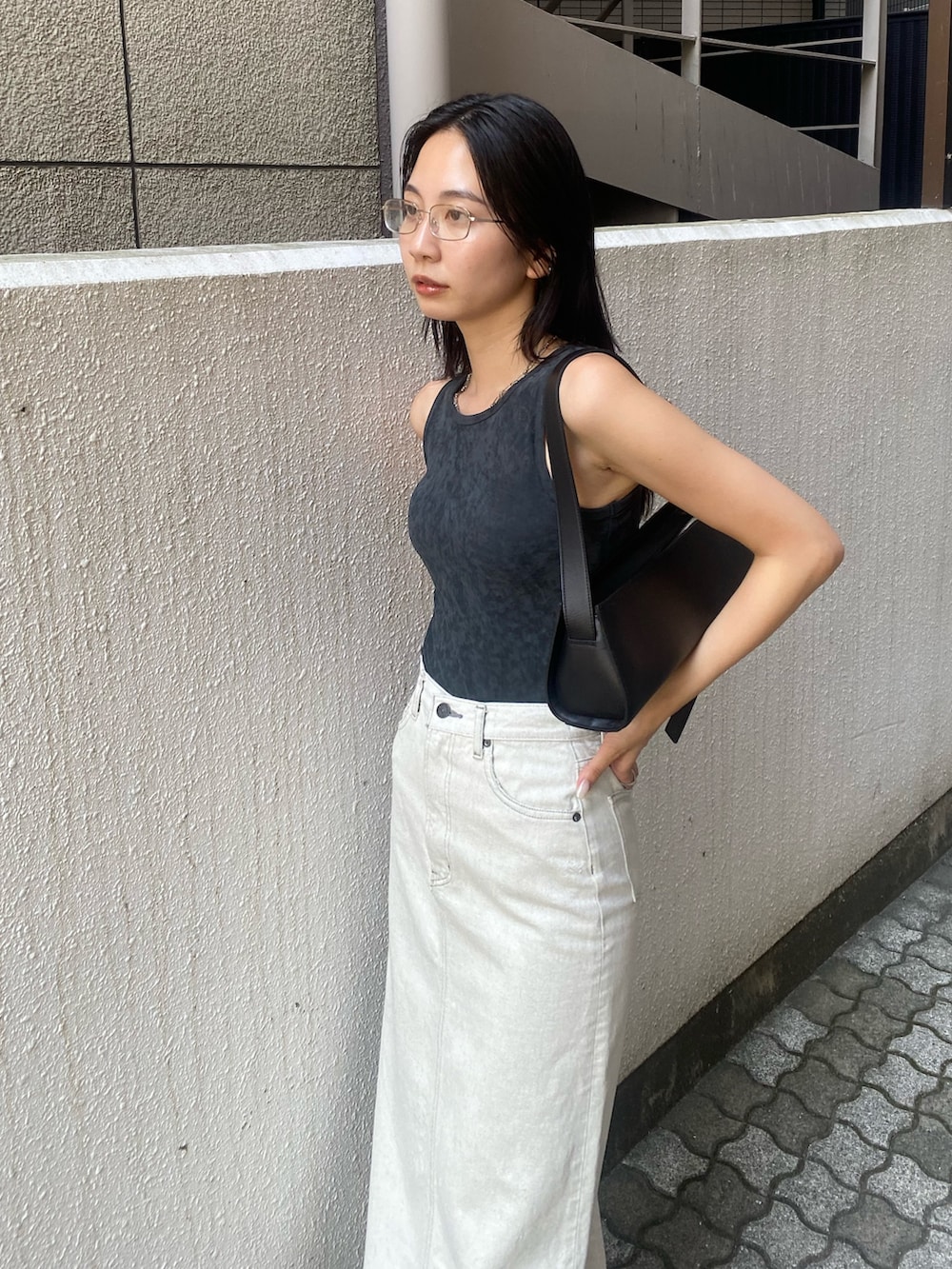 グレー系のタンクトップ、ホワイト系のスカートを着用したレディースの夏コーディネートの3枚目の写真