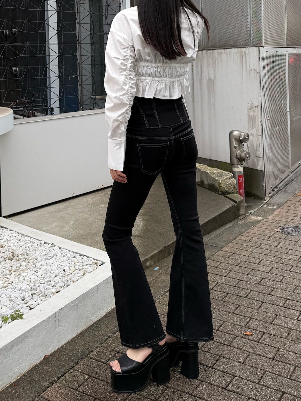 ブラック系のデニムパンツ、ホワイト系のシャツ/ブラウス、ブラック系のサンダルを着用したレディースの冬コーディネートの2枚目の写真