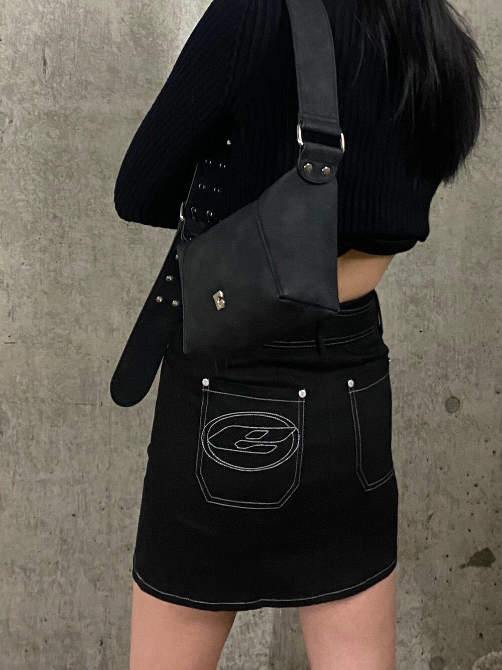 ブラック系のスカート、ブラック系のブルゾン、ブラック系のニット/セーターを着用したレディースの冬コーディネートの4枚目の写真