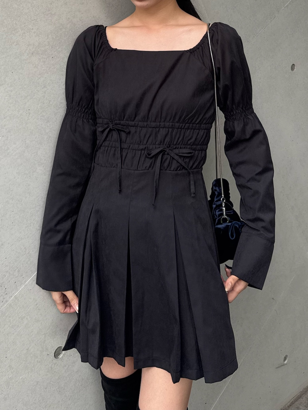 ブラック系のブーツ、ブラック系のワンピースを着用したレディースの冬コーディネートの2枚目の写真