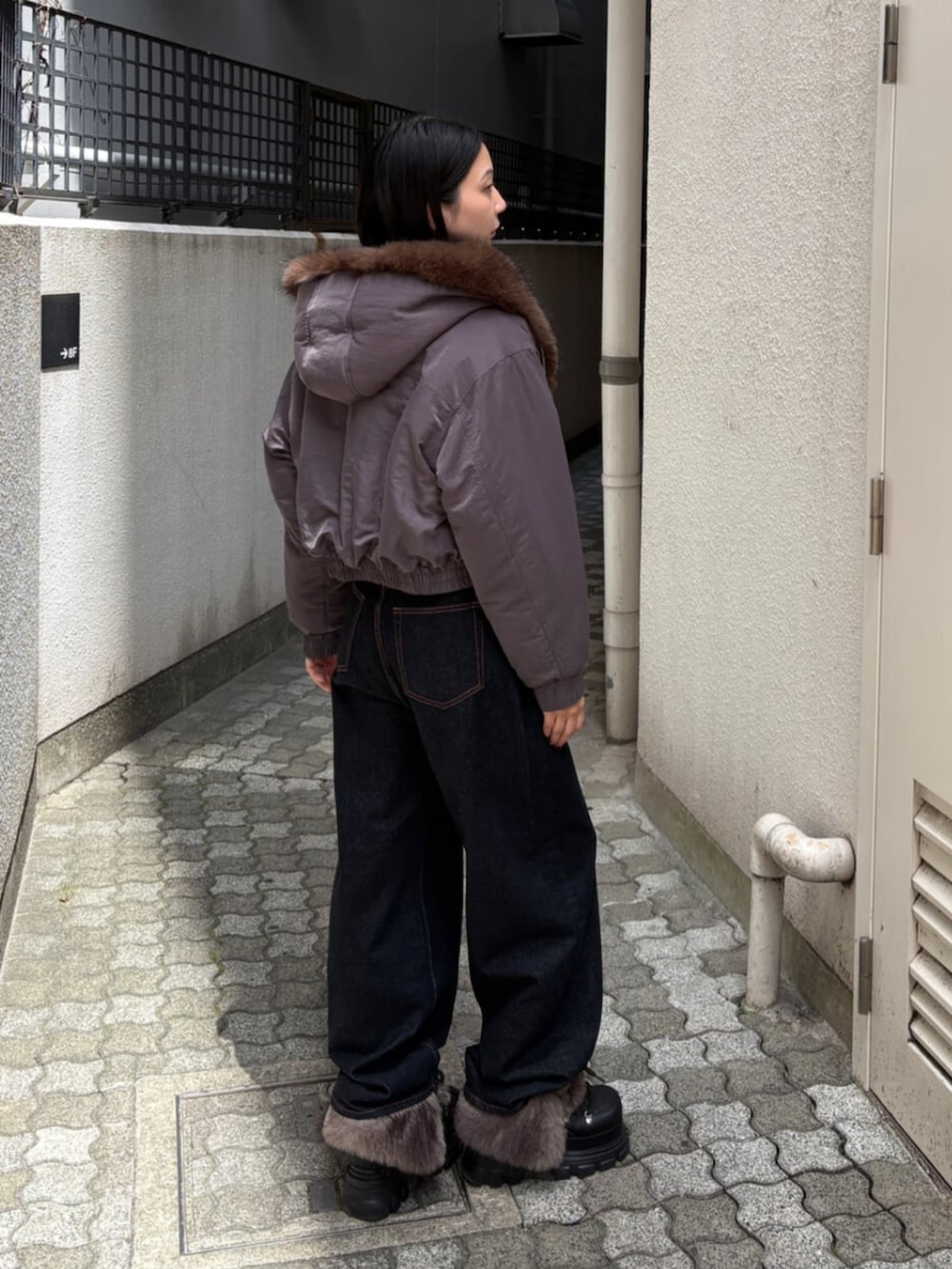ブルー系のデニムパンツ、グレー系のブルゾン、ブラック系のブーツを着用したレディースの秋コーディネートの4枚目の写真