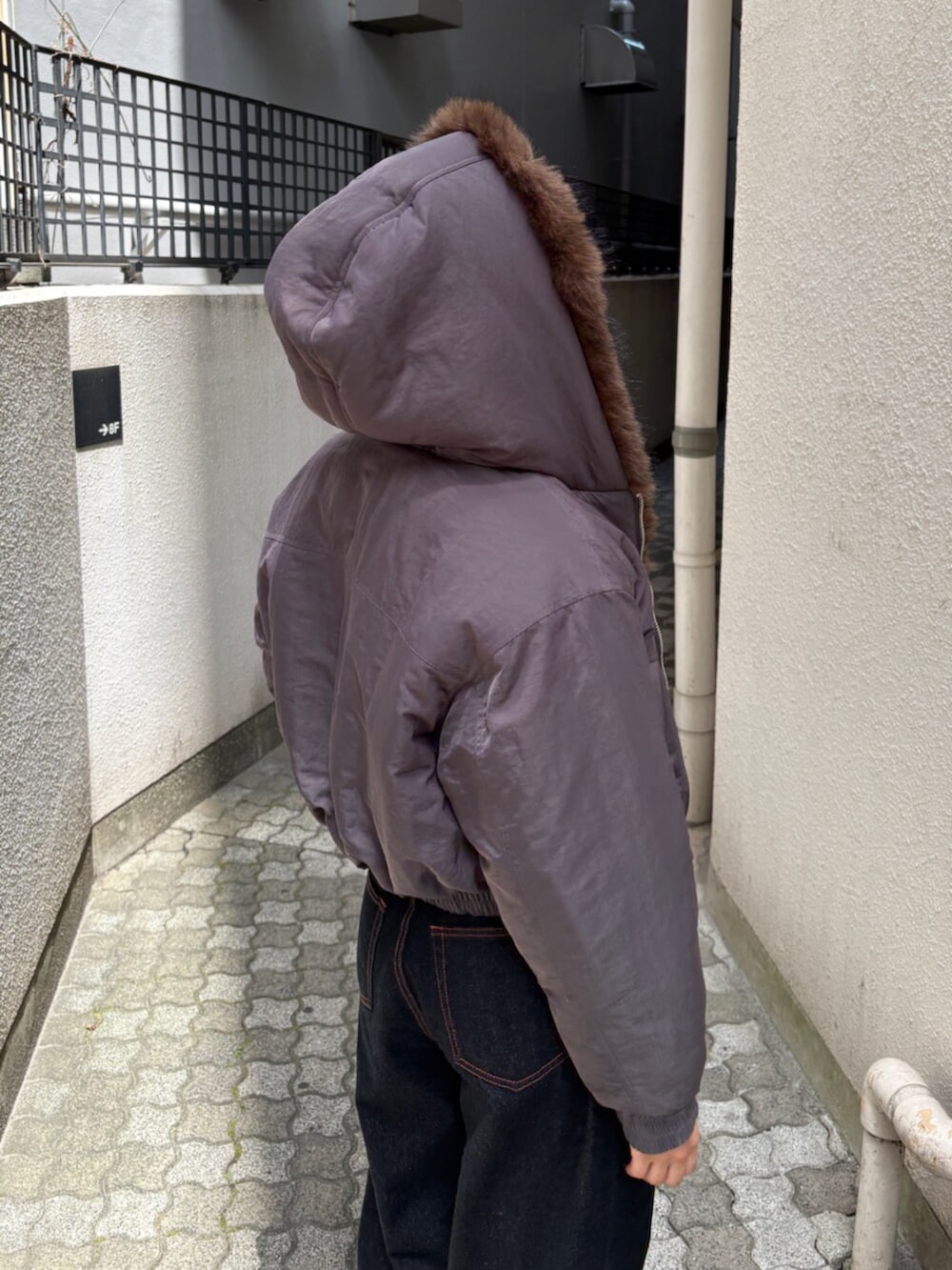 ブルー系のデニムパンツ、グレー系のブルゾン、ブラック系のブーツを着用したレディースの秋コーディネートの6枚目の写真